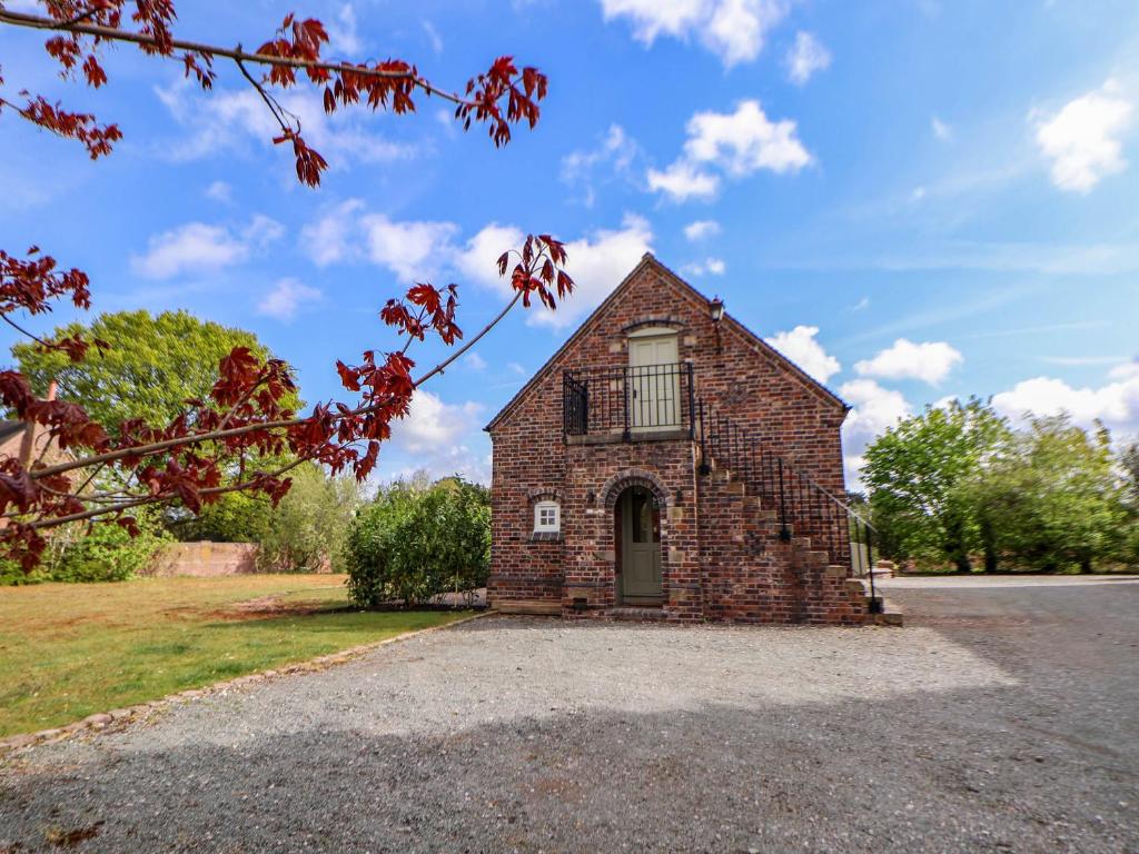 an old brick building with a balcony on the front at Egerton Cottage in Crewe