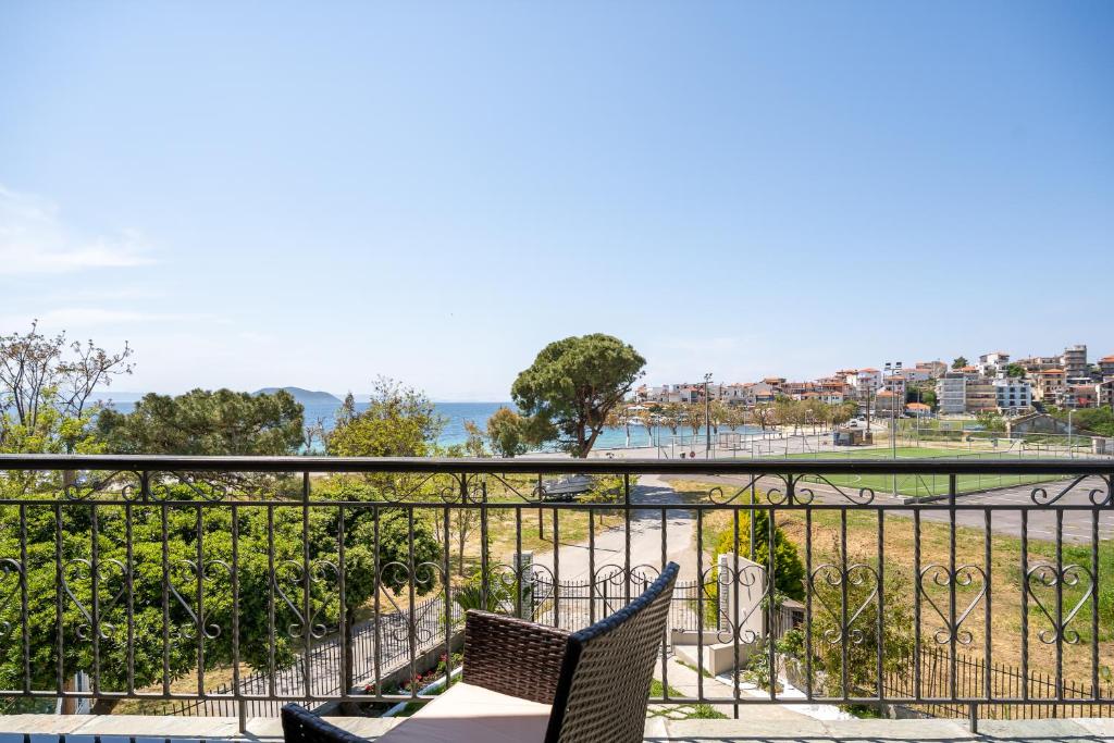 a balcony with two chairs and a view of the ocean at Sithonia Blue in Neos Marmaras