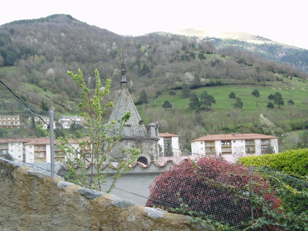 un edificio antiguo con una colina en el fondo en El Pomer, en Ribes de Freser