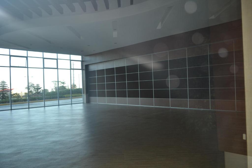 an empty room with a tiled wall and windows at Wind Residences Tagaytay City in Tagaytay