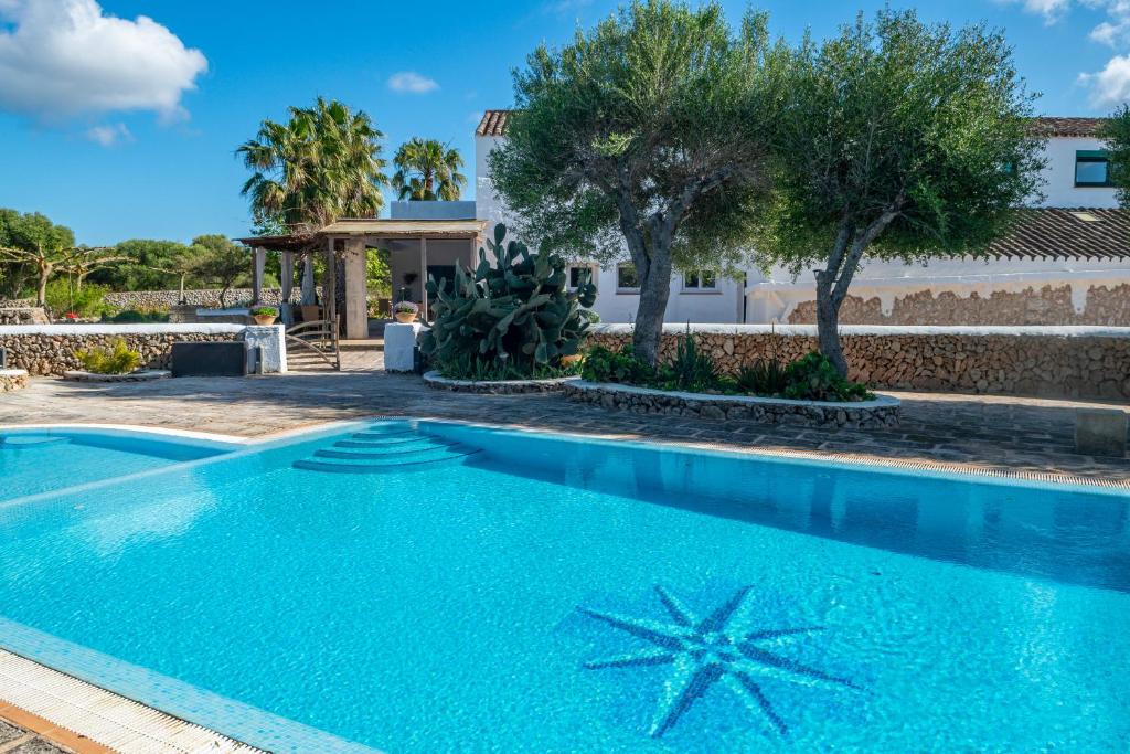 a swimming pool in front of a house at Turismo Rural Biniati des Pi in Sant Lluis