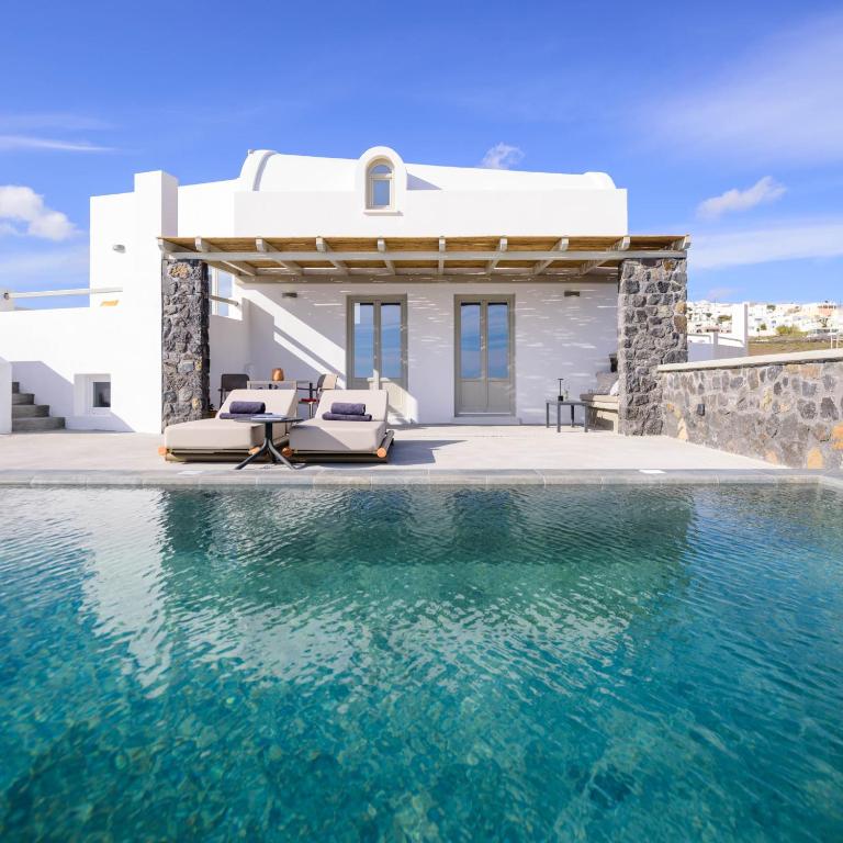 a villa with a swimming pool in front of a house at Avan Luxury Villas in Pyrgos