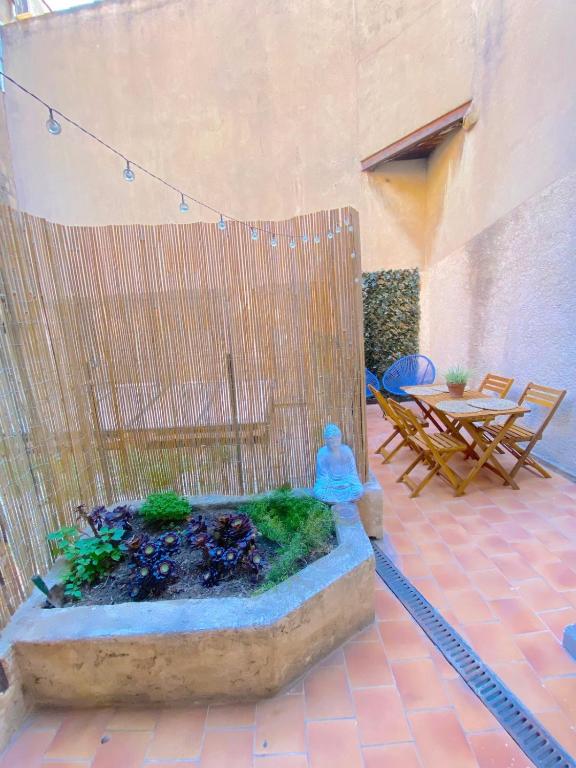un patio avec une fontaine avec une table et des chaises dans l'établissement Grand T3 à 20 mètres du port, à Sanary-sur-Mer
