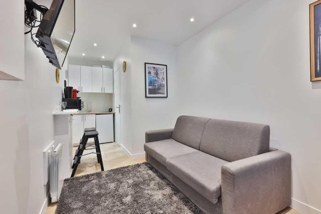 un salon avec un canapé et une cuisine dans l'établissement Close to Marais l 20min from Louvre by transport, à Paris