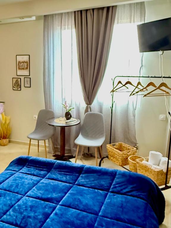 a bedroom with a blue bed and a table and chairs at Sunny apartment in Serres