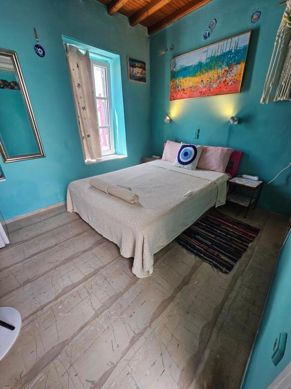 a bedroom with a large bed in a blue room at LaLaLand in Mikonos