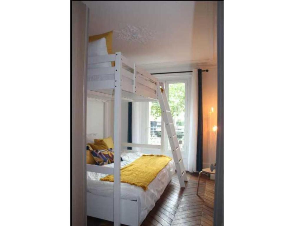 une chambre avec un lit superposé avec une échelle dans l'établissement Elegant apartement - AC 2BR-6P- Palais des Congrès, à Paris