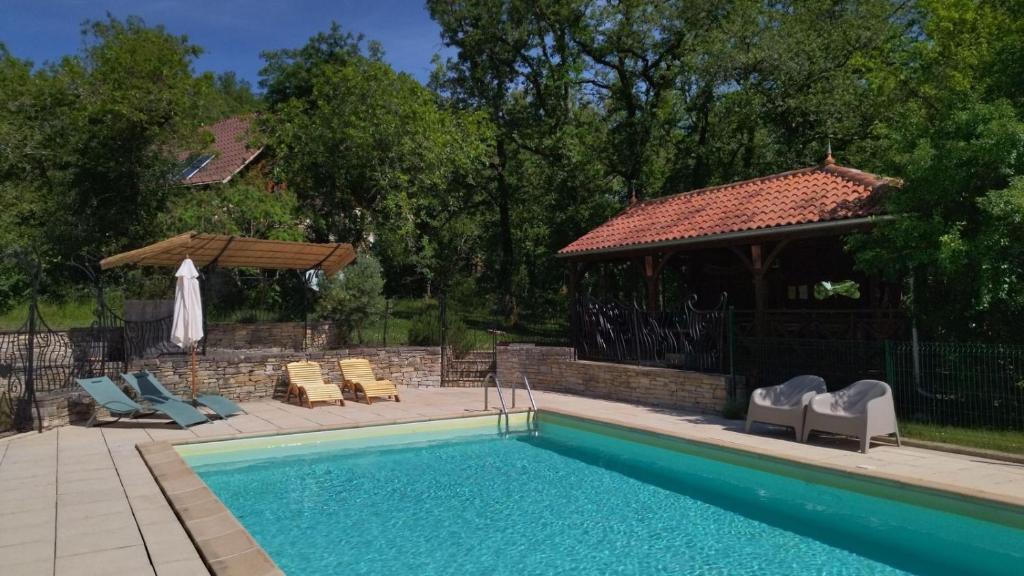 une piscine avec des chaises et un gazebo dans l'établissement Le Bois De Barthes, à Lavercantière