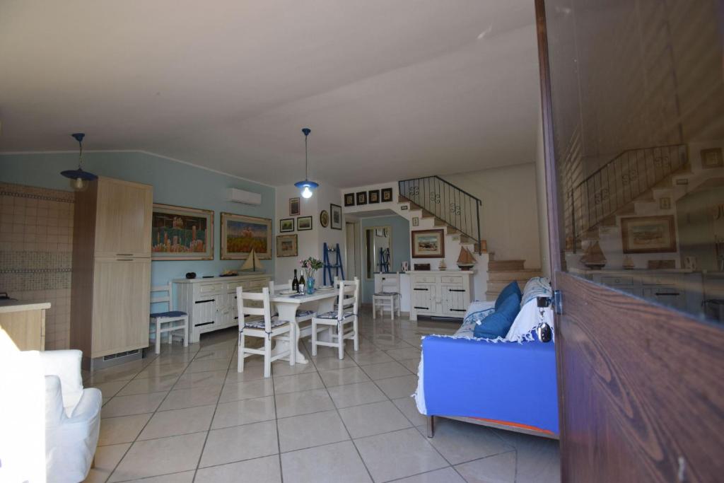 a living room with a blue couch and a table at Villino Le Palme, Laghi Di Sibari, Cosenza in I Casoni