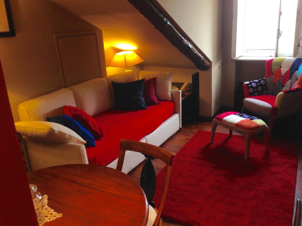 トリノにあるSanti apartment in the heart of Turinのリビングルーム(赤いソファ、テーブル付)