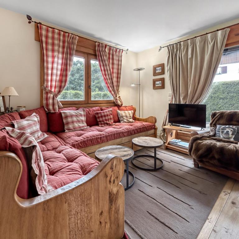un salon avec un canapé et une télévision dans l'établissement Appartement cosy T3 avec Terrasse, Jardin & Garage, à Megève