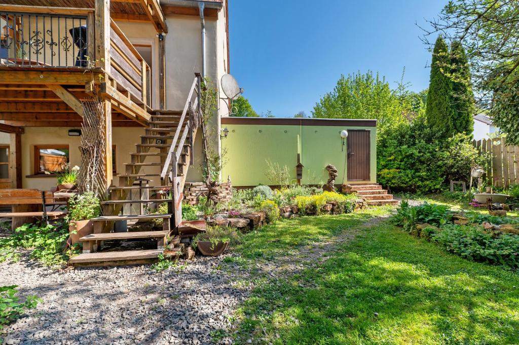 a house with a staircase to the side of it at Im Vital Art Naturgarten in Zweibrücken