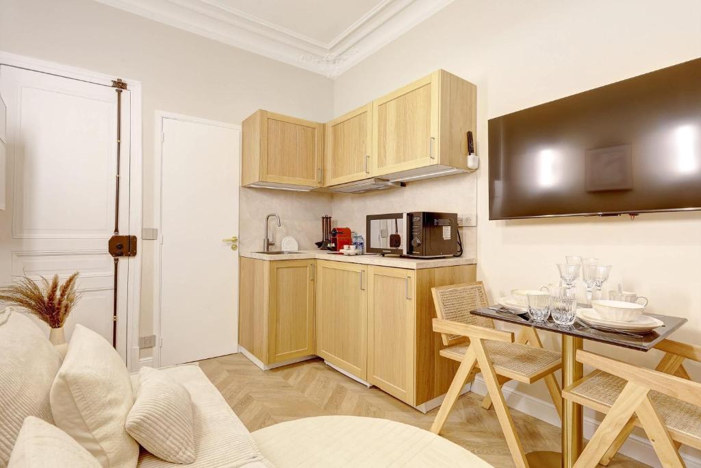 - une cuisine avec des placards en bois et une table dans une pièce dans l'établissement Studio luxueux a Paris with AC a proximite du Marais, à Paris