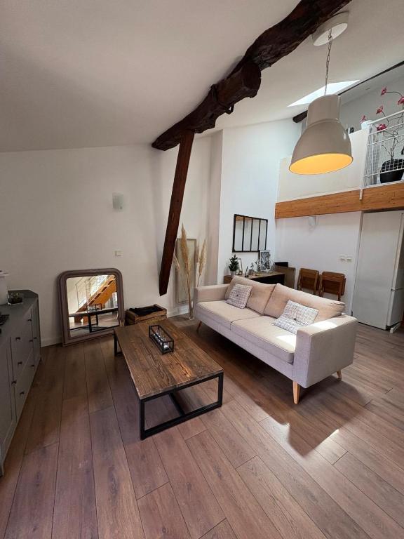 a living room with a white couch and a table at "Le Dix", emplacement exceptionnel, parking inclus in Montauban