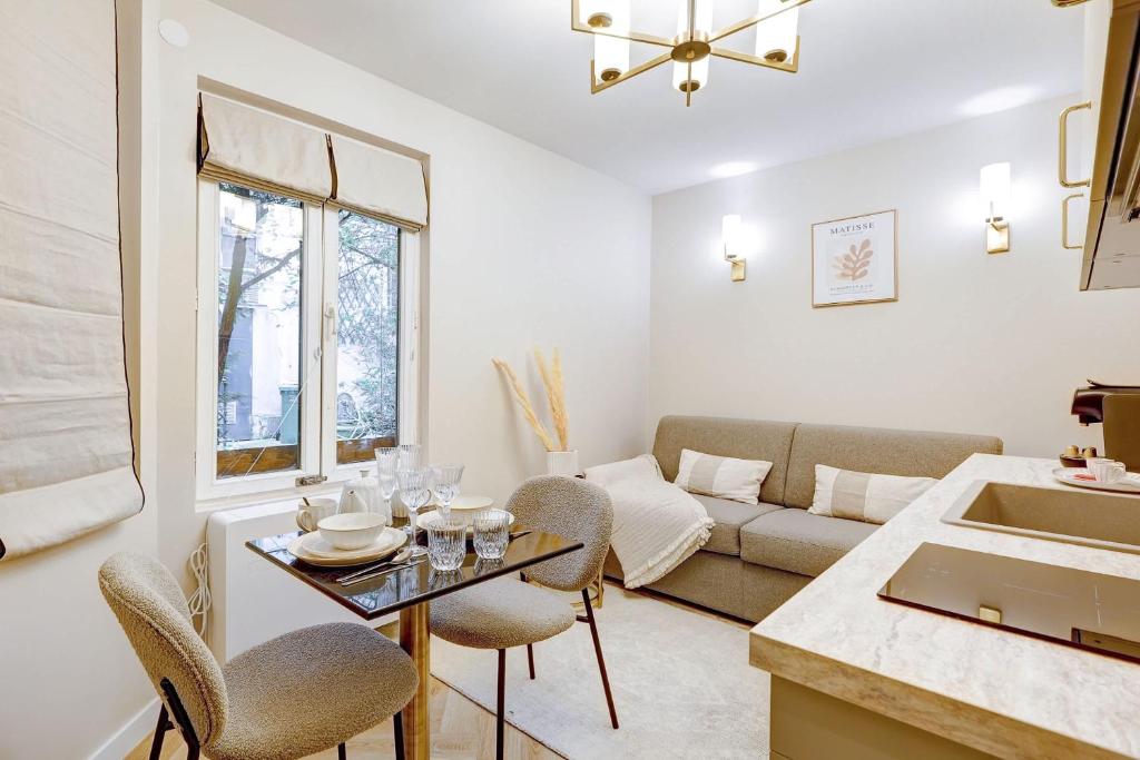 un salon avec un canapé et une table dans l'établissement Charming studio with A-C, à Paris