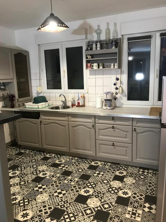 Il comprend une cuisine dotée de carrelage noir et blanc. dans l'établissement Duplex, à La Celle-sous-Gouzon