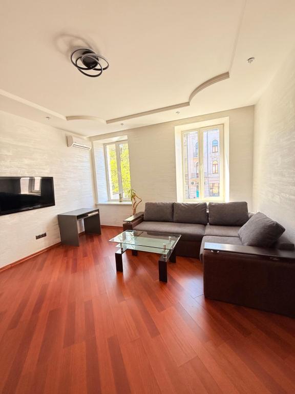 Una sala de estar con un sofá y una mesa de café. en светлая квартира, en Odessa