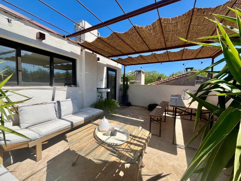 d'une terrasse avec un canapé et une table. dans l'établissement Maison Nomade, Clim - Terrasse, à Arles