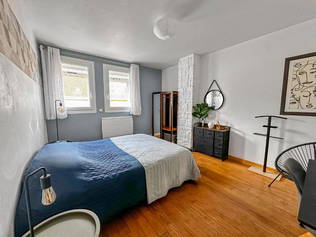 a bedroom with a bed and a chair in it at Grande maison familiale à deux pas de la mer in Le Portel