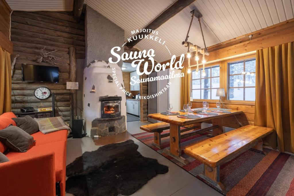 a living room with a table and a fireplace at Kuukkeli Log Houses Aurora Cabin - Jaspis in Saariselka
