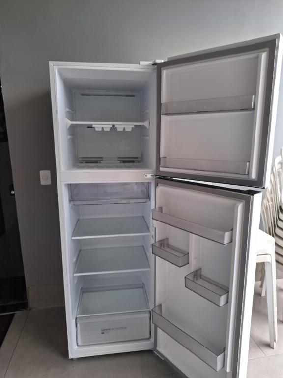an empty refrigerator with its door open in a kitchen at Mundial Chalés e Ecoturismo in Delfinópolis