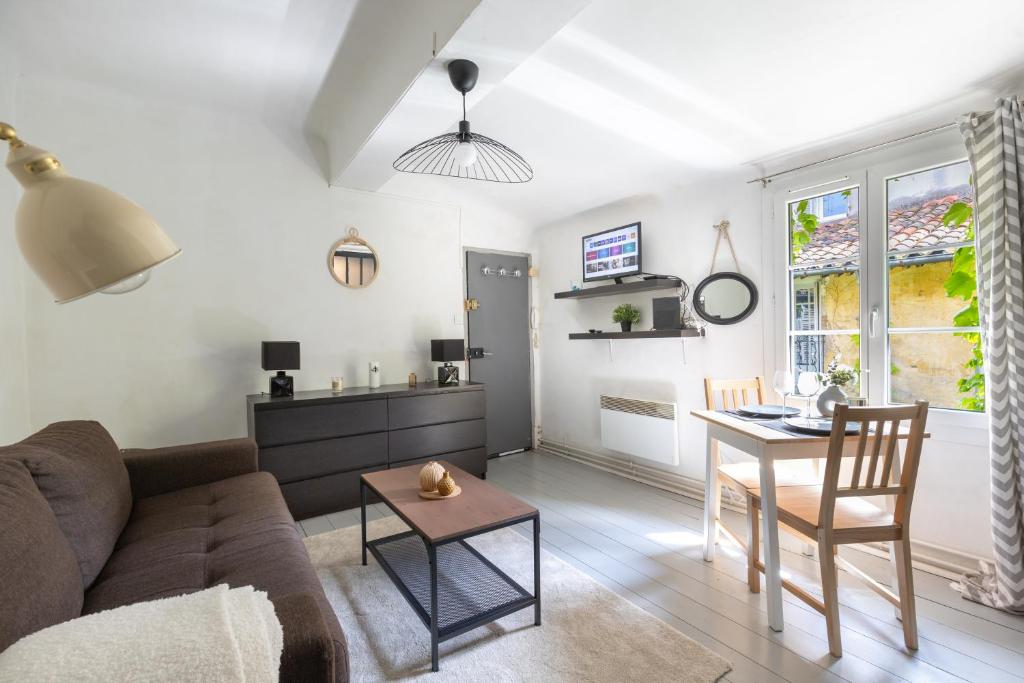 un salon avec un canapé et une table dans l'établissement Le Mirabeau - Hypercenter studio - Wifi - Train station, à Aix-en-Provence