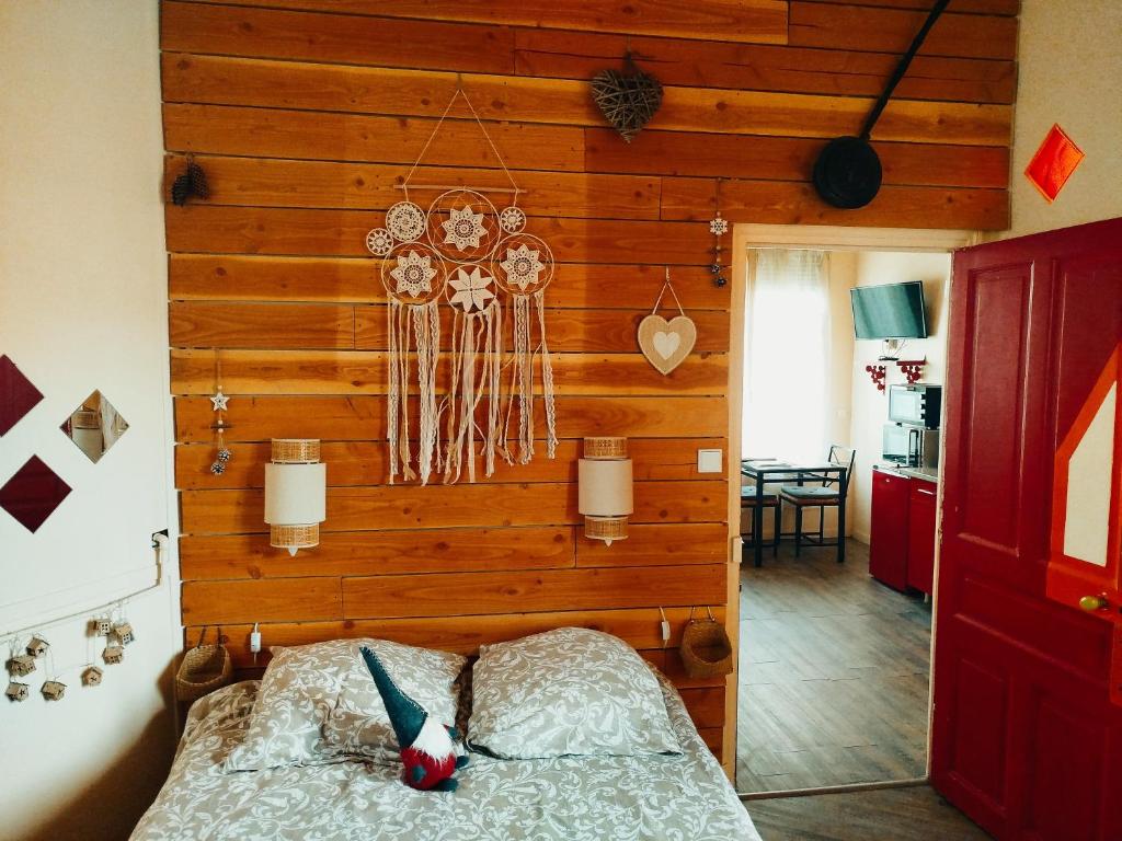 - une chambre avec un mur en bois et un lit dans l'établissement Appartement La Bourboule Antigua, à La Bourboule