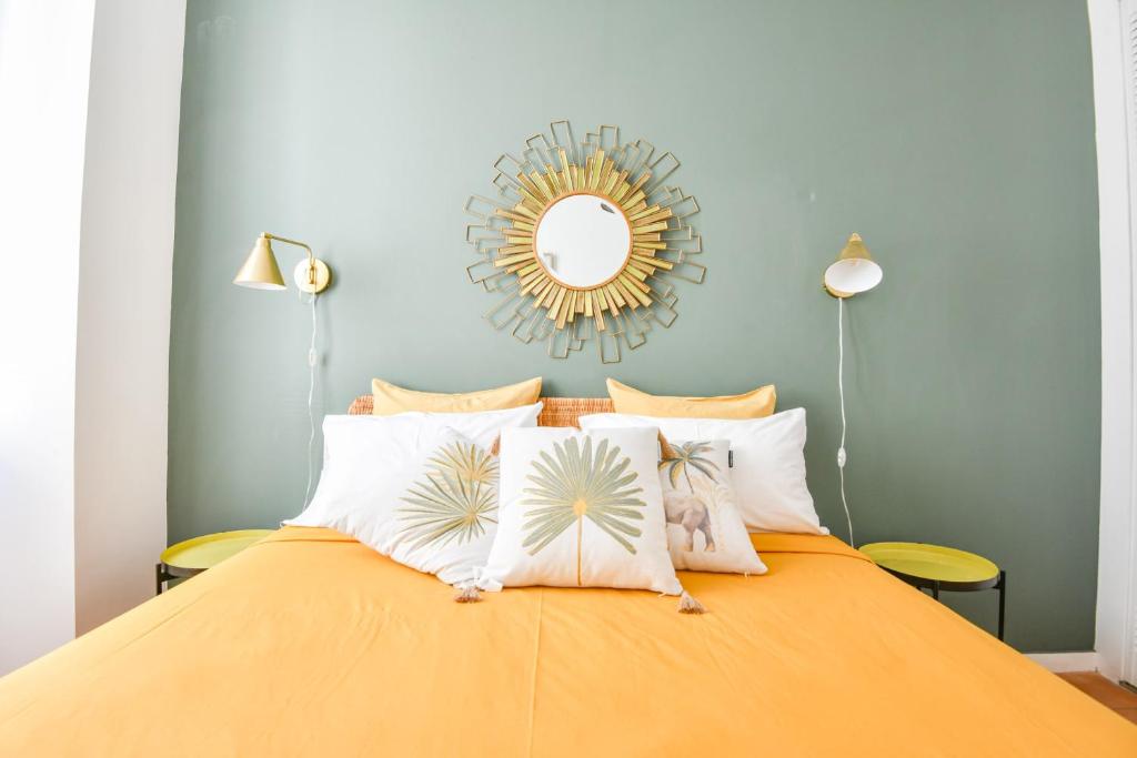 - une chambre avec un lit orange et un miroir dans l'établissement Chez Marius - Appart 1 ch avec clim - St Charles, à Marseille