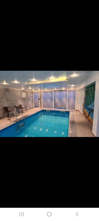 a large swimming pool in a building with a table at Private swimming pool sweet dreams in Sarajevo