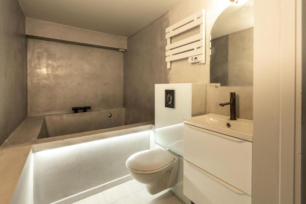 a bathroom with a toilet and a tub and a sink at Touchlux villa in Cannes