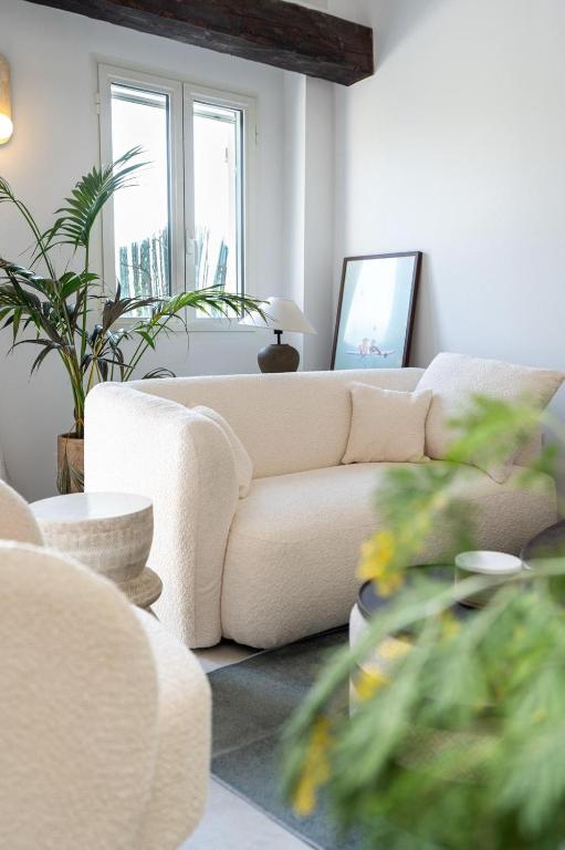 a living room with a white couch and some plants at Maison Azur -Luxury Townhouse Garden -Parking -Croix des Gardes in Cannes