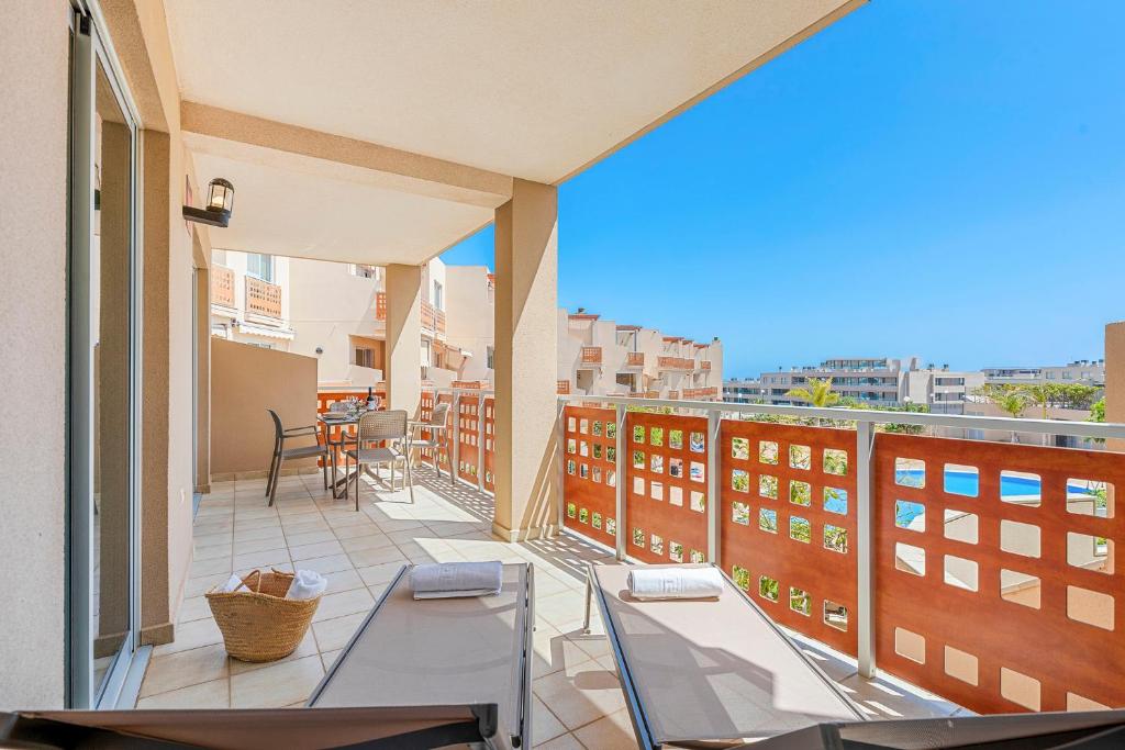 a balcony with chairs and a view of a city at MEDANO4YOU Hello Beach! Holiday Home in La Tejita