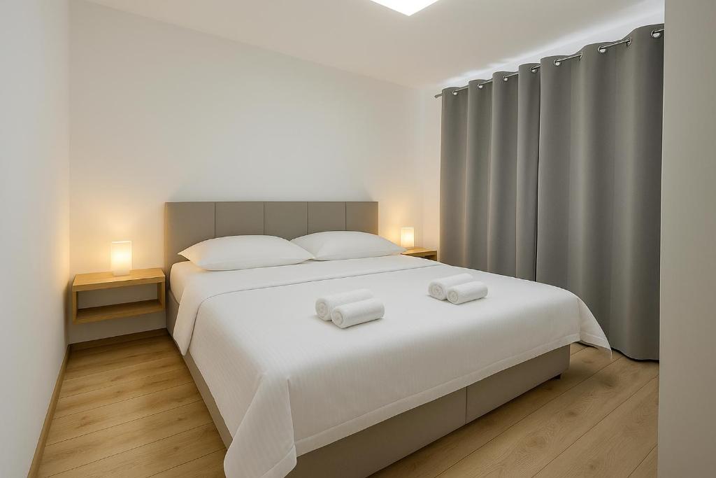 a bedroom with a white bed with two towels on it at Simcity V I City center,garage,balcony & self check-in in Banská Bystrica