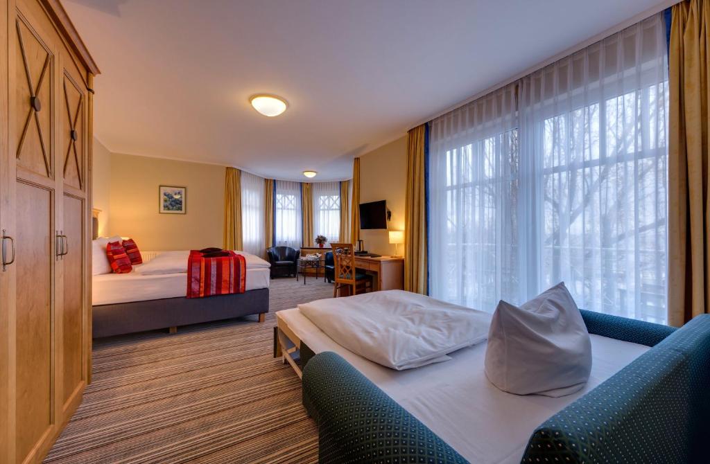 a hotel room with two beds and a window at Hotel Aquamarin in Kühlungsborn