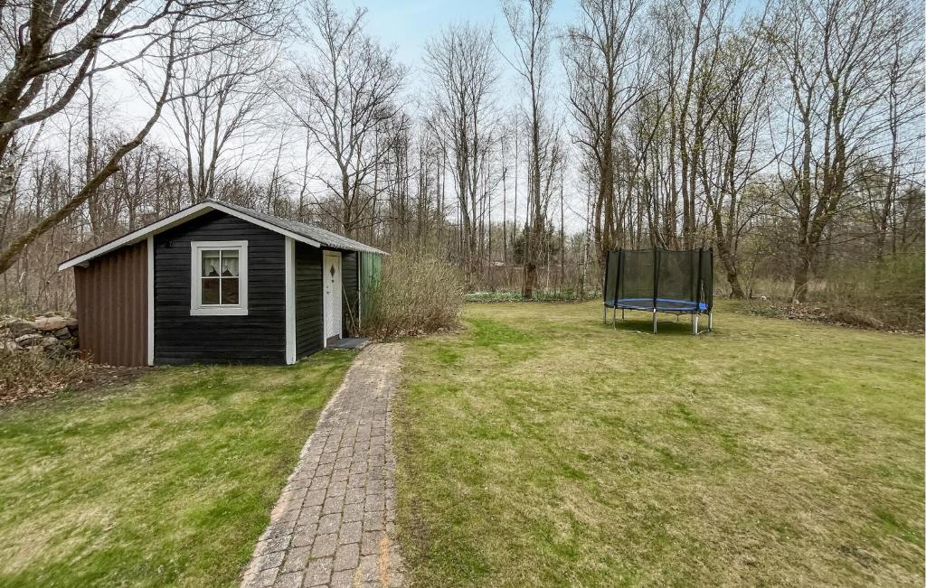 a small shed in a field with a bench at 3 Bedroom Beautiful Home In Hörby in Hörby