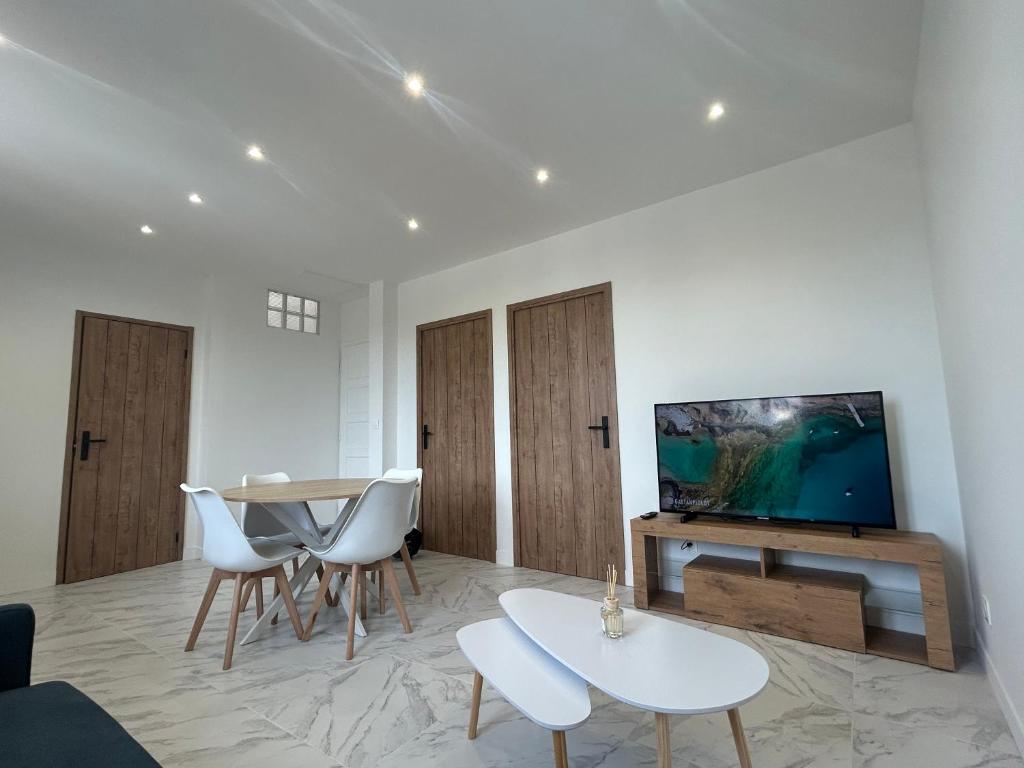 un salon avec une télévision, une table et des chaises dans l'établissement Appartement T3, Wi-Fi ,climatisé 2ème étage et dernier étage, à Marseille