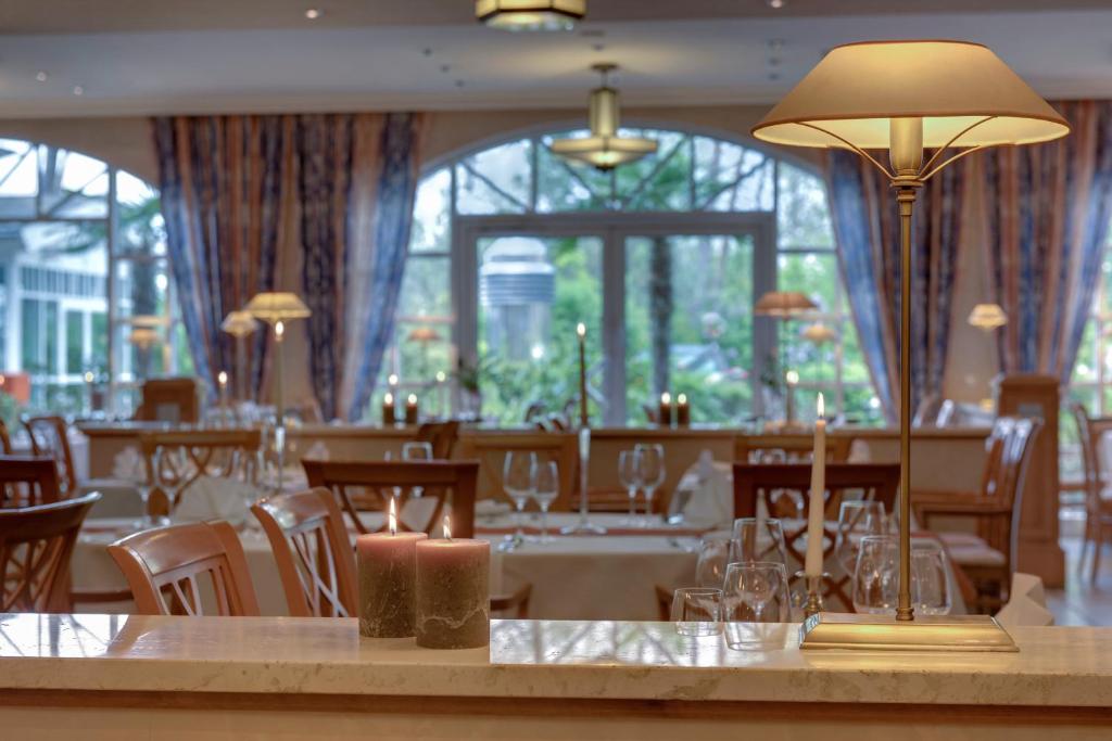 a dining room with tables and chairs and windows at Hotel Aquamarin in Kühlungsborn