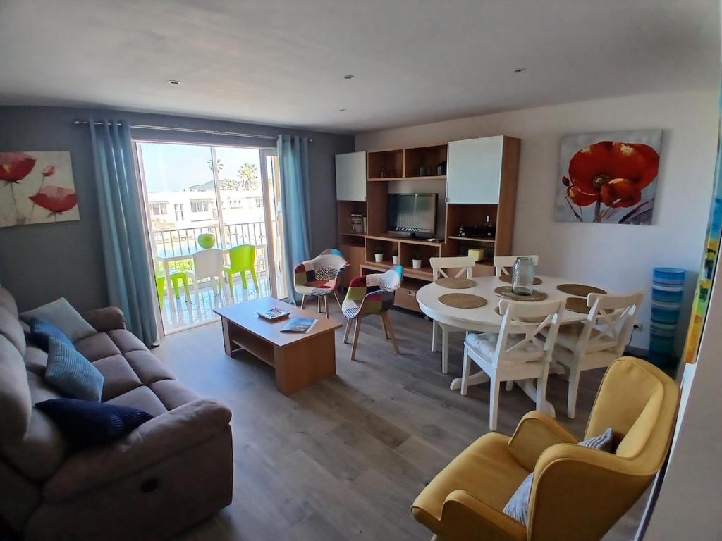 ein Wohnzimmer mit einer Couch und einem Tisch und Stühlen in der Unterkunft Petit Paradis aux Lones 2 min de la plage 3 chambres clim parking aperçu mer in Six-Fours-les-Plages