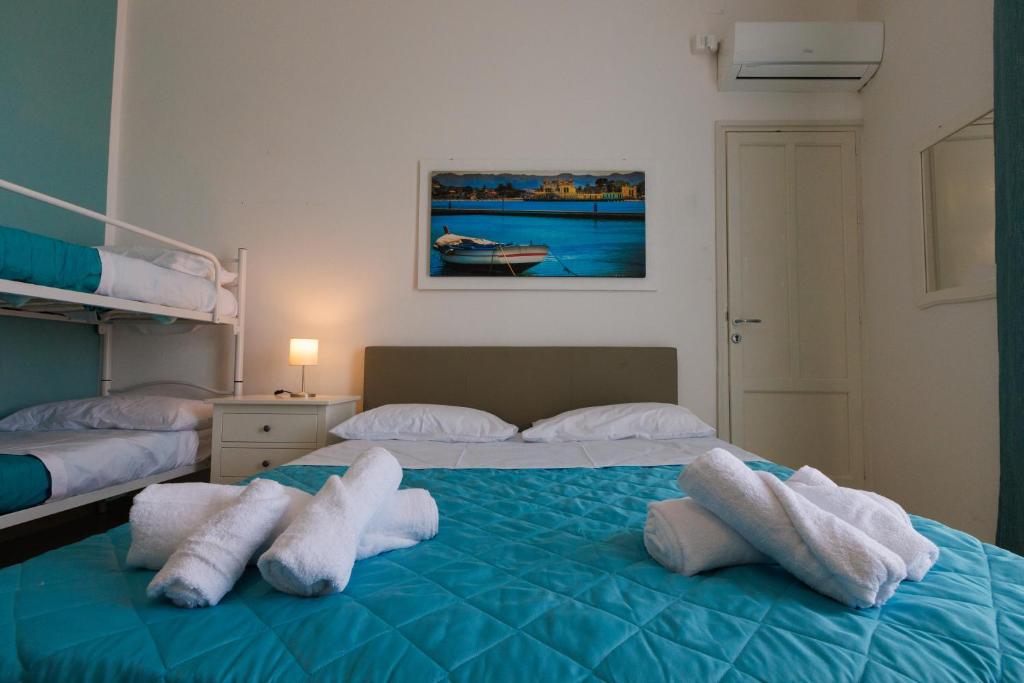 a bedroom with two beds with towels on them at Donna Rosalía Apartments in Trabia
