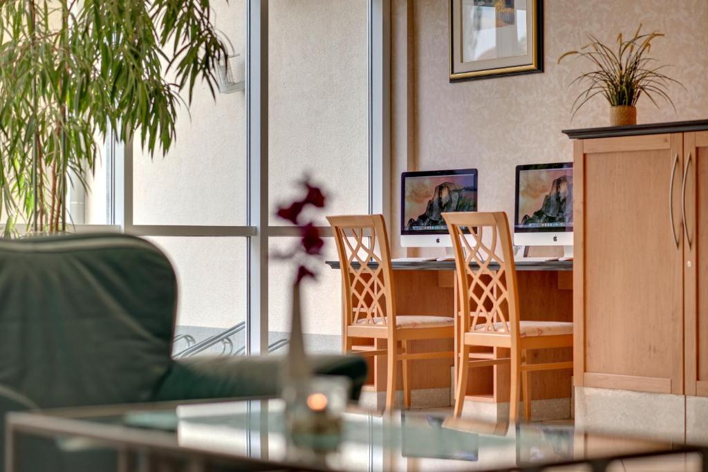 a room with two chairs and a desk with two computers at Hotel Aquamarin in Kühlungsborn