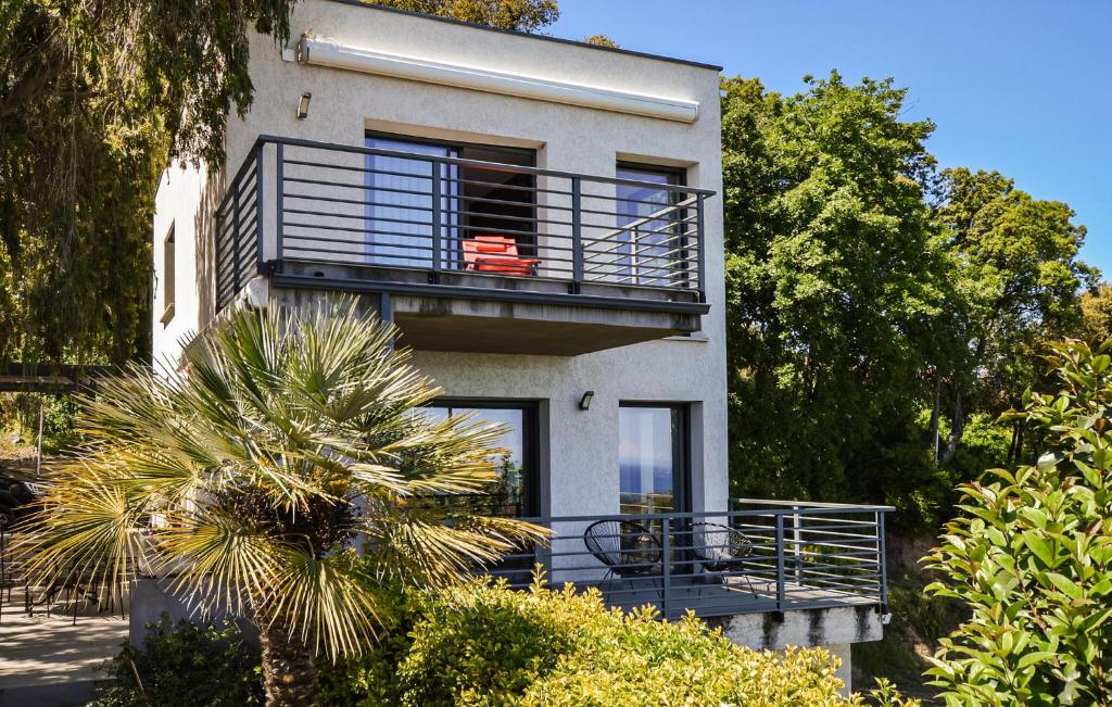 un bâtiment avec un balcon et un palmier dans l'établissement 2 Bedroom Lovely Home In Cervione, à Cervione