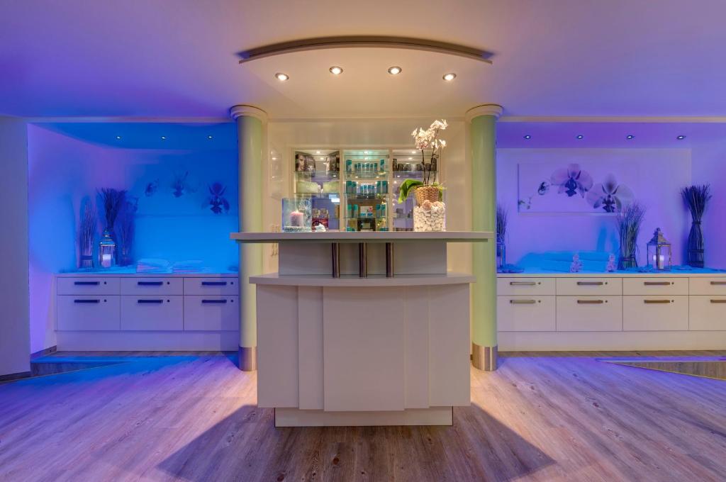 a large kitchen with white cabinets and blue walls at Hotel Aquamarin in Kühlungsborn