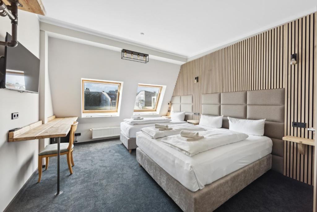 een hotelkamer met twee bedden en een bureau bij Hotel Comenius in Berlijn