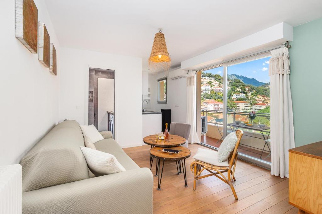 罗克布吕讷-卡普马丹FLOR DE MAYO - Agréable appartement -Proche Mer - Parking Gratuit的客厅里有一张沙发和一张桌子。