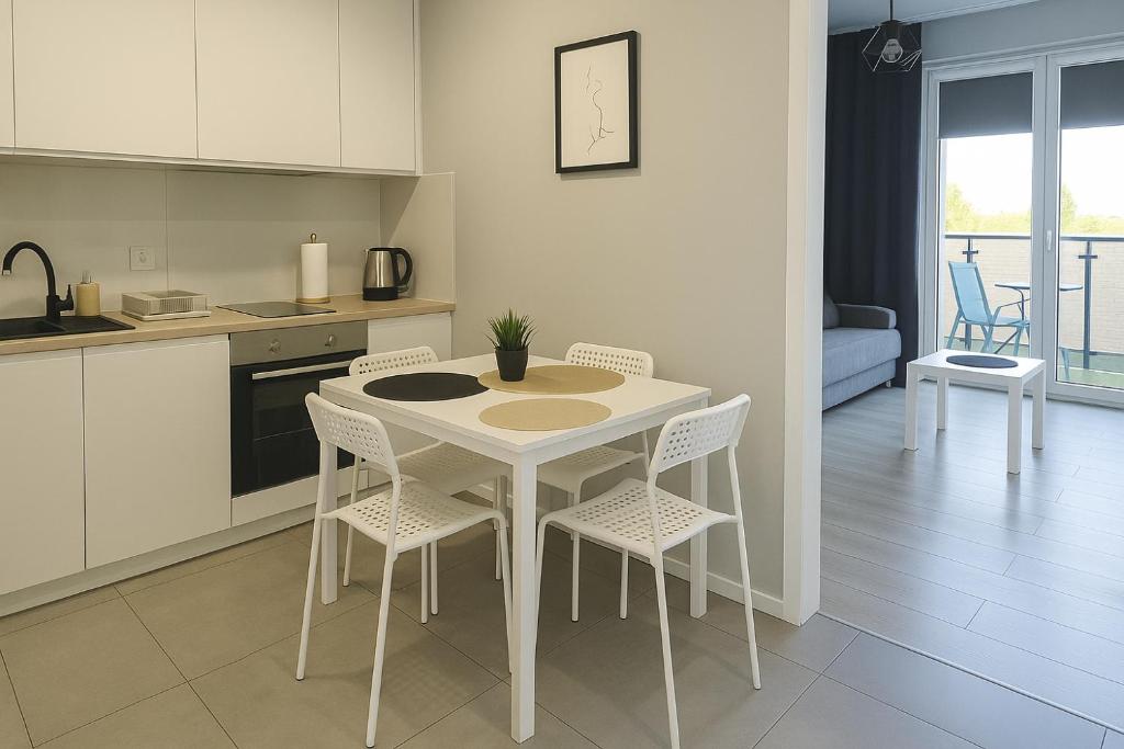 une cuisine avec une table et des chaises dans une cuisine dans l'établissement Urban Jungle - Silver Apartment, à Białystok