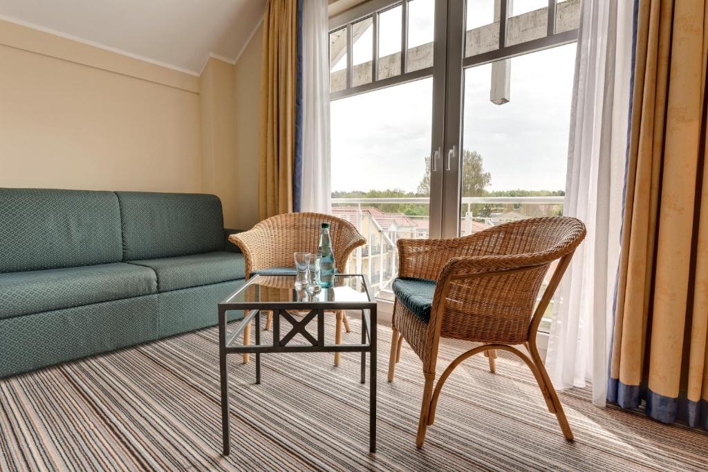 a living room with a couch and chairs and a table at Hotel Aquamarin in Kühlungsborn