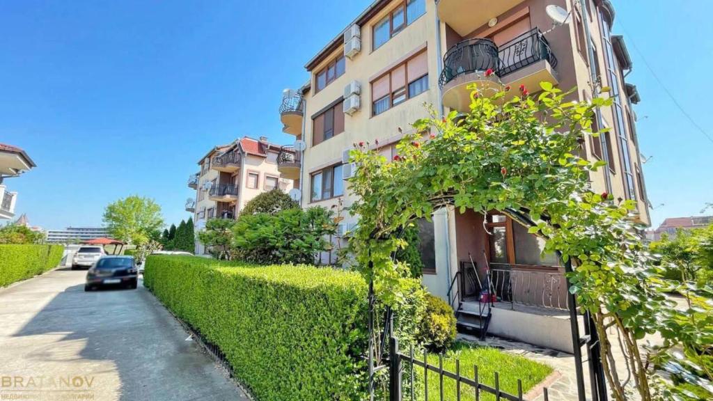 Un edificio con una siepe vicino a una strada di Apartment Chocolate Ravda a Ravda