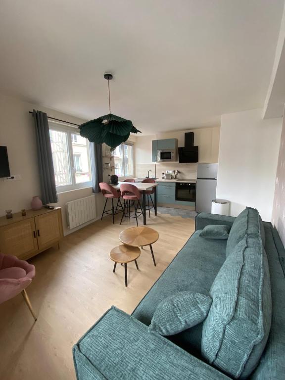 un salon avec un canapé bleu et une cuisine dans l'établissement Juvanedi, à Rouen