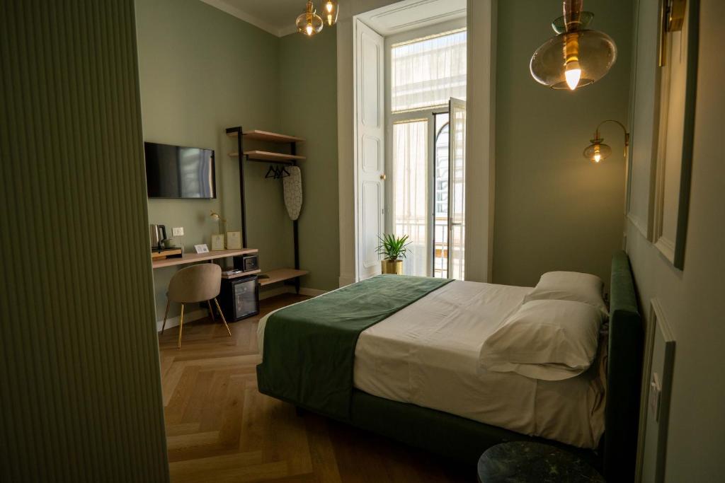 una camera da letto con un letto, una scrivania e una finestra di Boutique Luxury Suite a Napoli