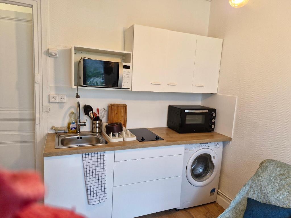 La cuisine est équipée d'un évier, d'un four micro-ondes et d'un lave-linge. dans l'établissement Bobillot, à Paris